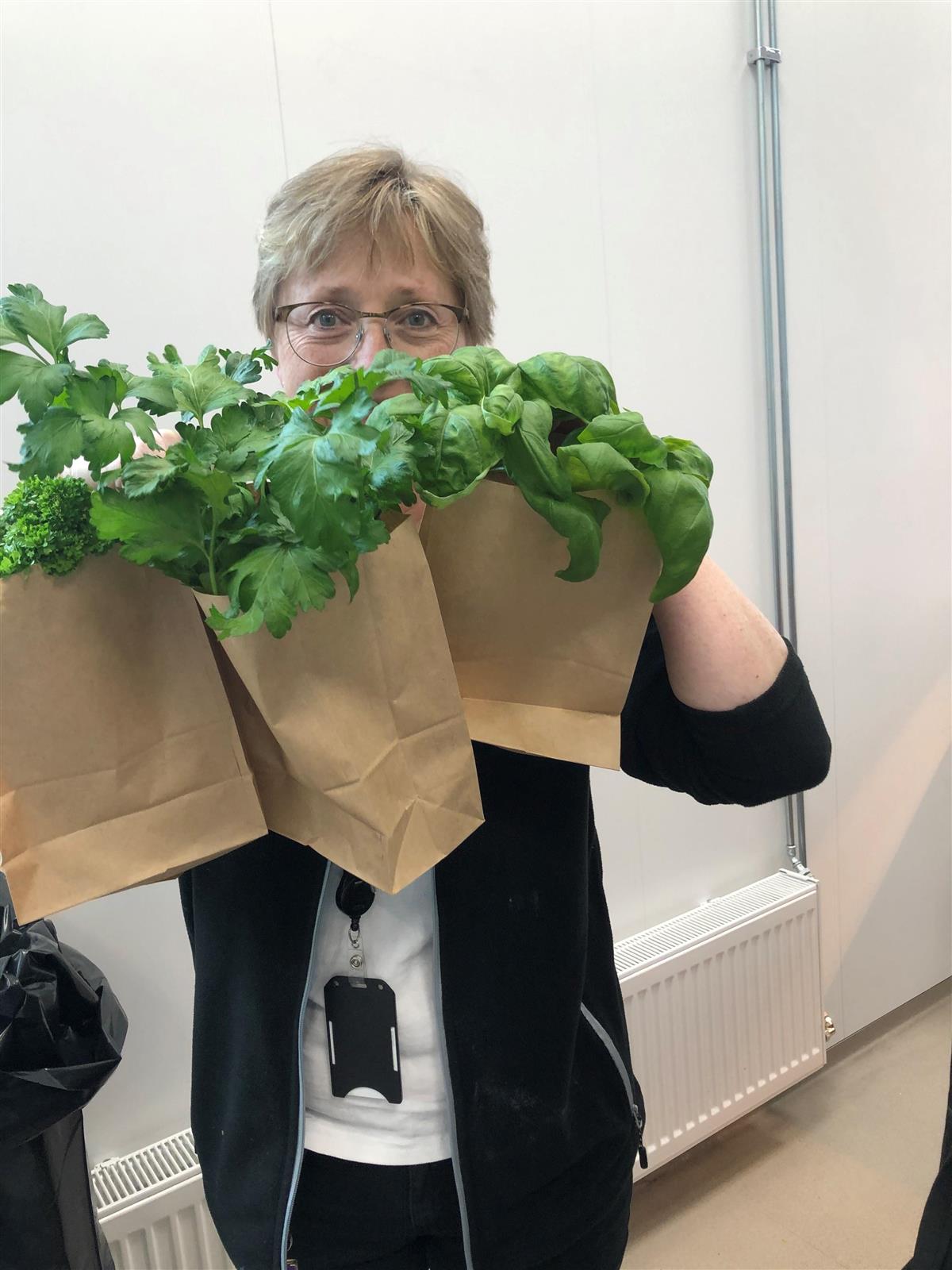 Kvinne holder friske urter i papirpose - Klikk for stort bilde